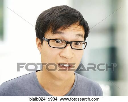 Young man, Asian, student with glasses, smiling, surprised View Large Photo Image Picture - Young man, Asian, student with glasses, smiling, surprised. Fotosearch