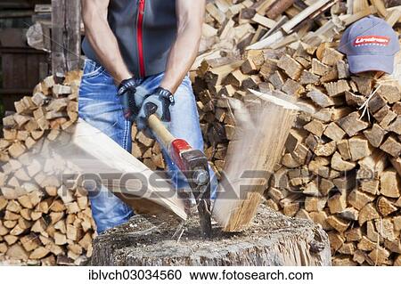 Stock Image - "Young man chopping wood, Reith im Alpbachtal, Kufstein District, North Tirol, Tirol, Austria, Europe". Fotosearch