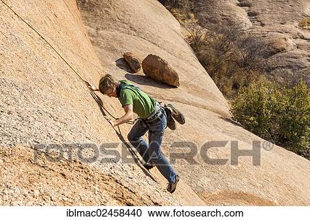"Young man climbing at Bogenfels, Spitzkoppe area, Damaraland, Namibia, Africa" View Large Photo Image Stock Image - "Young man climbing at Bogenfels, Spitzkoppe area, Damaraland, Namibia, Africa". Fotosearch