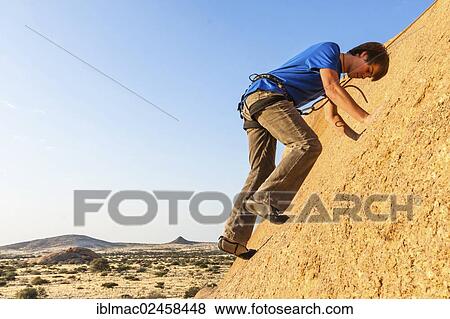 "Young man climbing at Bogenfels, Spitzkoppe area, Damaraland, Namibia, Africa" View Large Photo Image Stock Photo - "Young man climbing at Bogenfels, Spitzkoppe area, Damaraland, Namibia, Africa". Fotosearch