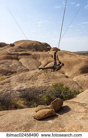 "Young man hanging from a climbing rope, Bogenfels, Spitzkoppe area, Namibia, Africa" View Large Photo Image Stock Image - "Young man hanging from a climbing rope, Bogenfels, Spitzkoppe area, Namibia, Africa". Fotosearch