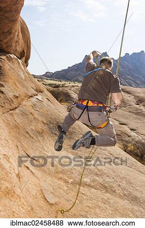 "Young man hanging from a climbing rope, Bogenfels, Spitzkoppe area, Namibia, Africa" View Large Photo Image Stock Photo - "Young man hanging from a climbing rope, Bogenfels, Spitzkoppe area, Namibia, Africa". Fotosearch