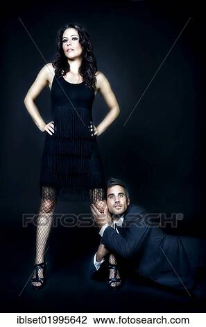 Young man hanging onto the leg of a strong young woman View Large Photo Image Stock Image - Young man hanging onto the leg of a strong young woman. Fotosearch