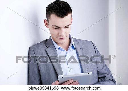 Young man holding a tablet computer View Large Photo Image Stock Photo - Young man holding a tablet computer. Fotosearch