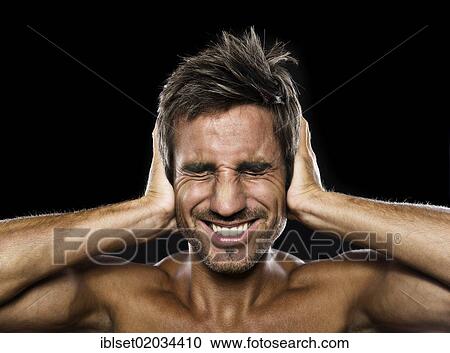 Young man holding his hands against his ears View Large Photo Image Stock Image - Young man holding his hands against his ears. Fotosearch