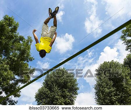"Young man jumping on a slackline, Waiblingen, Baden-Wurttemberg, Germany, Europe" View Large Photo Image Stock Photography - "Young man jumping on a slackline, Waiblingen, Baden-Wurttemberg, Germany, Europe". Fotosearch