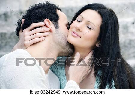 Stock Photo - "Young man kissing a young woman's neck, Austria, Europe". Fotosearch
