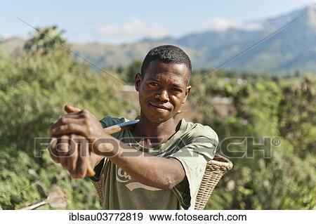 Stock Photo - "Young man of the Antandroy people carrying a basket for field work, Tolagnara, Madagascar, Africa". Fotosearch