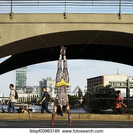 "Young man painted in Polynesian patterns doing a handstand on a street, Oberbaumbrucke bridge, Berlin, Germany, Europe" View Large Photo Image Stock Photo - "Young man painted in Polynesian patterns doing a handstand on a street, Oberbaumbrucke bridge, Berlin, Germany, Europe". Fotosearch