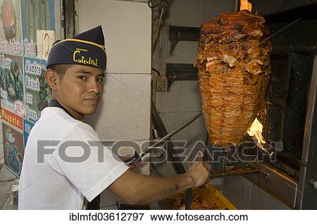 "Young man preparing tacos al pastor, Puebla, Puebla, Mexico, North America" View Large Photo Image Stock Photo - "Young man preparing tacos al pastor, Puebla, Puebla, Mexico, North America". Fotosearch