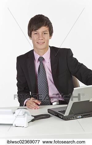 Young man sitting at a laptop View Large Photo Image Stock Photo - Young man sitting at a laptop. Fotosearch