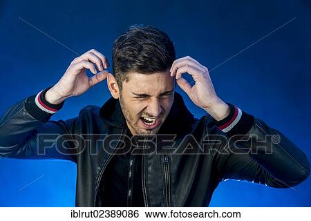 Stock Photograph - "Young man wearing a black leather jacket, with an aggressive or angry expression". Fotosearch