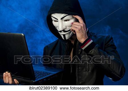 "Young man wearing an anonymous mask with a hood and a black leather jacket, holding a laptop, making a thoughtful gesture" View Large Photo Image Stock Image - "Young man wearing an anonymous mask with a hood and a black leather jacket, holding a laptop, making a thoughtful gesture". Fotosearch
