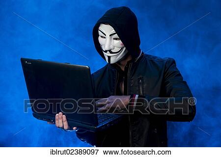 "Young man wearing an anonymous mask with a hood and a black leather jacket, holding a laptop" View Large Photo Image Stock Photo - "Young man wearing an anonymous mask with a hood and a black leather jacket, holding a laptop". Fotosearch