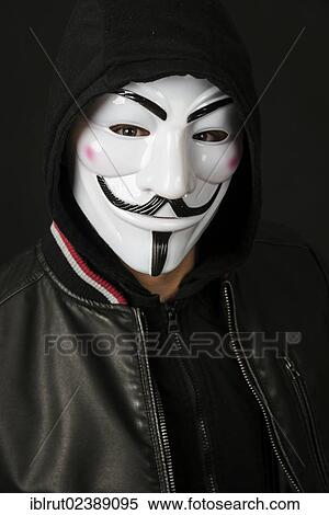 Stock Photography - Young man wearing an anonymous mask with a hood and a black leather jacket. Fotosearch