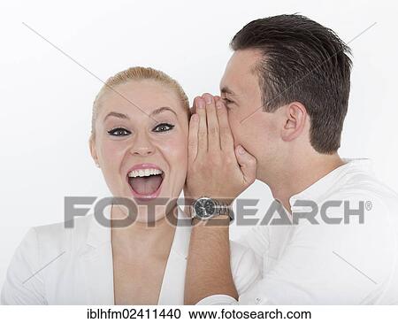 "Young man whispering something into the ear of his young partner, which she receives joyfully, symbolic image for good news" View Large Photo Image Stock Image - "Young man whispering something into the ear of his young partner, which she receives joyfully, symbolic image for good news". Fotosearch