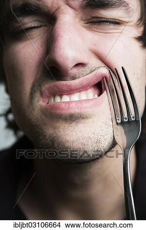 "Young man with a fork in his lip, Germany, Europe" View Large Photo Image Picture - "Young man with a fork in his lip, Germany, Europe". Fotosearch