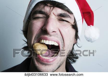 "Young Man with a Santa hat, walnut between his teeth, nutcracker, Germany, Europe" View Large Photo Image Stock Image - "Young Man with a Santa hat, walnut between his teeth, nutcracker, Germany, Europe". Fotosearch