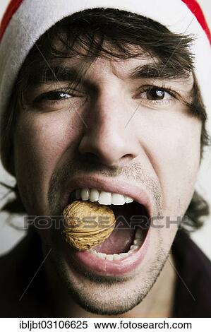 "Young Man with a Santa hat, walnut between his teeth, nutcracker, Germany, Europe" View Large Photo Image Stock Photography - "Young Man with a Santa hat, walnut between his teeth, nutcracker, Germany, Europe". Fotosearch