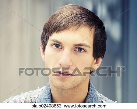 "Young man with a serious face wearing a studded denim jacket, portrait" View Large Photo Image Stock Image - "Young man with a serious face wearing a studded denim jacket, portrait". Fotosearch