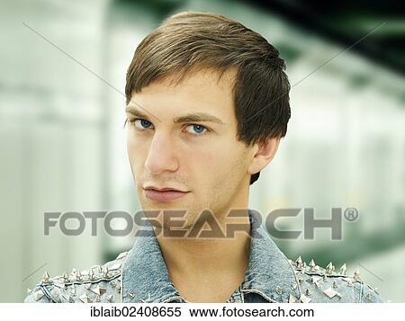 Stock Photography - "Young man with a serious face wearing a studded denim jacket, portrait". Fotosearch