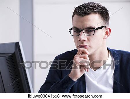 Stock Photo - Young man working on a computer. Fotosearch