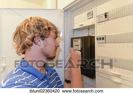Young man writing down the meter reading in a fuse box View Large Photo Image Stock Image - Young man writing down the meter reading in a fuse box. Fotosearch