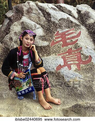 "Young Miao woman wearing a traditional ethnic costume in front of rocks with a Chinese inscription, Hainan, China, Asia" View Large Photo Image Stock Photography - "Young Miao woman wearing a traditional ethnic costume in front of rocks with a Chinese inscription, Hainan, China, Asia". Fotosearch