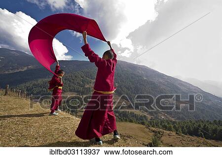 "Young monks wearing red cloths flying kite with a blanket at a mountain slope, Junbesi, Solukhumbu District, Sagarmatha Zone, Nepal, Asia" View Large Photo Image Stock Photo - "Young monks wearing red cloths flying kite with a blanket at a mountain slope, Junbesi, Solukhumbu District, Sagarmatha Zone, Nepal, Asia". Fotosearch