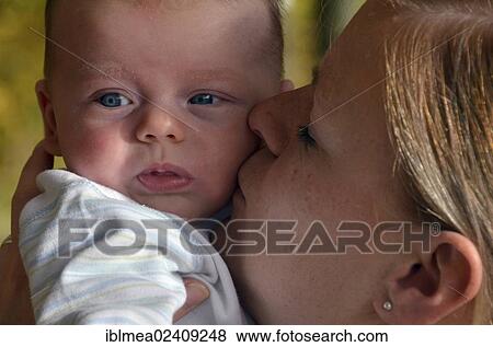 Young mother caressing an infant View Large Photo Image Stock Photo - Young mother caressing an infant. Fotosearch