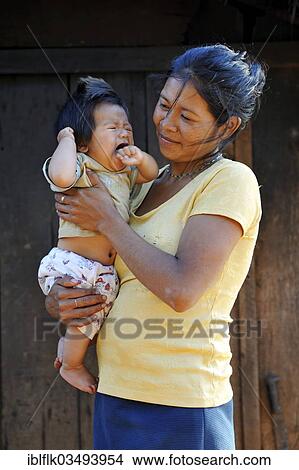 "Young mother holding a crying child in her arms, in a community of Guarani Indians, Jaguary, Caaguazu Department, Paraguay, South America" View Large Photo Image Picture - "Young mother holding a crying child in her arms, in a community of Guarani Indians, Jaguary, Caaguazu Department, Paraguay, South America". Fotosearch