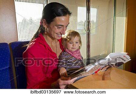 "Young mother with child reading in a booklet inside ICE train, Dresden, Saxony, Germany, Europe" View Large Photo Image Stock Photo - "Young mother with child reading in a booklet inside ICE train, Dresden, Saxony, Germany, Europe". Fotosearch