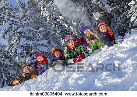 "Young people in colorful winter clothes lying happily side by side in the snow, behind a snowy coniferous forest, Tyrol, Austria, Europe" View Large Photo Image Picture - "Young people in colorful winter clothes lying happily side by side in the snow, behind a snowy coniferous forest, Tyrol, Austria, Europe". Fotosearch