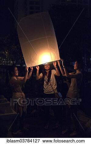 "Young people releasing a sky lantern or Kongming lantern, Chiang Mai, Thailand, Asia" View Large Photo Image Stock Photo - "Young people releasing a sky lantern or Kongming lantern, Chiang Mai, Thailand, Asia". Fotosearch
