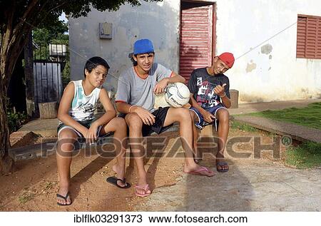 "Young people with a football sitting in front of their home in a favela, Poxoreo, Mato Grosso, Brazil, South America" View Large Photo Image Stock Image - "Young people with a football sitting in front of their home in a favela, Poxoreo, Mato Grosso, Brazil, South America". Fotosearch