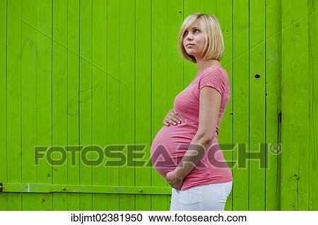 Stock Image - Young pregnant woman holding her belly. Fotosearch