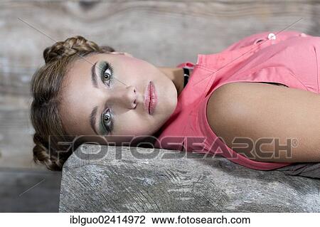 Young smiling woman wearing a pink sleeveless top lying on a wooden bench, portrait View Large Photo Image Stock Image - Young smiling woman wearing a pink sleeveless top lying on a wooden bench, portrait. Fotosearch