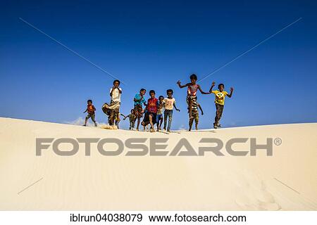 "Young Socotrian boys running in the sand dunes at the south coast of the island of Socotra, Yemen, Asia" View Large Photo Image Stock Photo - "Young Socotrian boys running in the sand dunes at the south coast of the island of Socotra, Yemen, Asia". Fotosearch