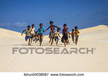 "Young Socotrian boys running in the sand dunes at the south coast of the island of Socotra, Yemen, Asia" View Large Photo Image Stock Photo - "Young Socotrian boys running in the sand dunes at the south coast of the island of Socotra, Yemen, Asia". Fotosearch