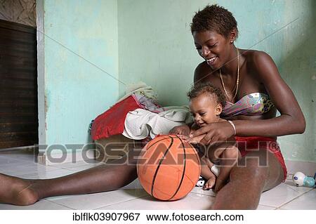 "Young woman, 15, former street child, playing with her younger brother, 1, with a basketball, Senador Camara favela, Rio de Janeiro, Rio de Janeiro State, Brazil, South America" View Large Photo Image Stock Photo - "Young woman, 15, former street child, playing with her younger brother, 1, with a basketball, Senador Camara favela, Rio de Janeiro, Rio de Janeiro State, Brazil, South America". Fotosearch