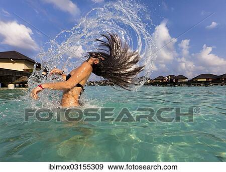 "Young woman, about 19 years, throwing her wet hair back, in a lagoon, Paradise Island at the back, Indian Ocean, Lankanfinolhu, North Male Atoll, Maldives, Asia" View Large Photo Image Stock Photo - "Young woman, about 19 years, throwing her wet hair back, in a lagoon, Paradise Island at the back, Indian Ocean, Lankanfinolhu, North Male Atoll, Maldives, Asia". Fotosearch