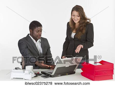 "Young woman and a young man in the office with a laptop computer, having a discussion" View Large Photo Image Stock Photo - "Young woman and a young man in the office with a laptop computer, having a discussion". Fotosearch