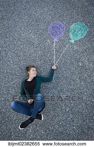 "Young woman appearing to be suspended from two painted balloons, taken from above" View Large Photo Image Stock Photography - "Young woman appearing to be suspended from two painted balloons, taken from above". Fotosearch
