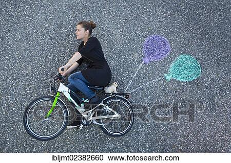 "Young woman appearing to cycle on a children's bicycle, painted balloons tied to the rack, taken from above" View Large Photo Image Stock Image - "Young woman appearing to cycle on a children's bicycle, painted balloons tied to the rack, taken from above". Fotosearch