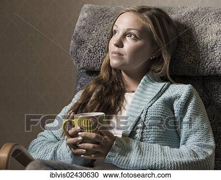 "Young woman at home, relaxing, holding a mug" View Large Photo Image Stock Image - "Young woman at home, relaxing, holding a mug". Fotosearch