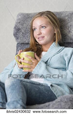 "Young woman at home, relaxing, holding a mug" View Large Photo Image Stock Image - "Young woman at home, relaxing, holding a mug". Fotosearch