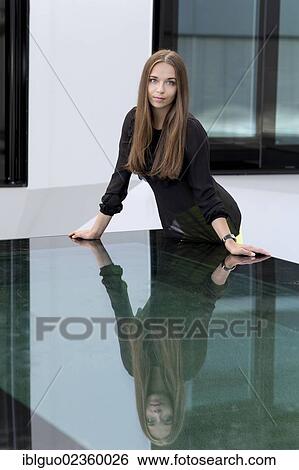 Stock Photograph - Young woman being reflected in a table. Fotosearch