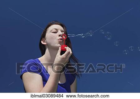 "Young woman blowing soap bubbles against a blue sky, Schwabische Alb, Baden-Wurttemberg, Germany, Europe" View Large Photo Image Picture - "Young woman blowing soap bubbles against a blue sky, Schwabische Alb, Baden-Wurttemberg, Germany, Europe". Fotosearch