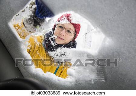 Young woman cleaning a car of ice and snow View Large Photo Image Stock Photo - Young woman cleaning a car of ice and snow. Fotosearch
