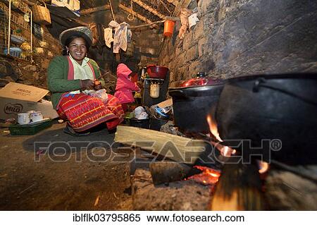 Stock Photography - "Young woman cooking on an open fire in her traditional kitchen, Union Potrero, Quispillacta, Ayacucho, Peru, South America". Fotosearch